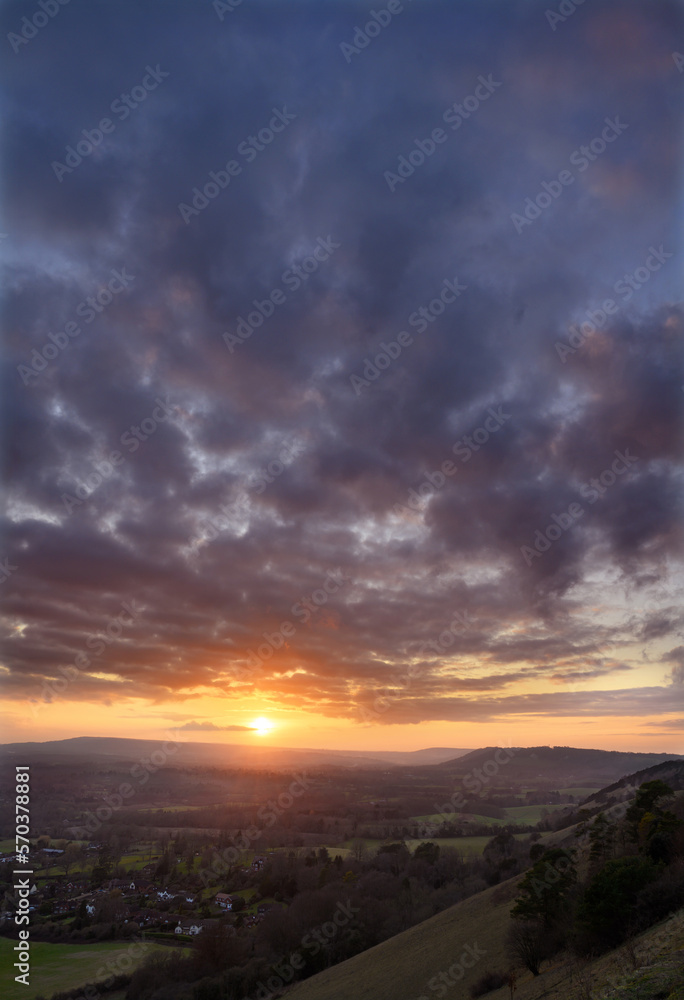 Sunset portrait view from Colley Hill between Reigate and Dorking in Surrey, UK. Surrey Hills area of Outstanding Natural Beauty on the North Downs. Looking towards Leith Hill on the Greensand Ridge.