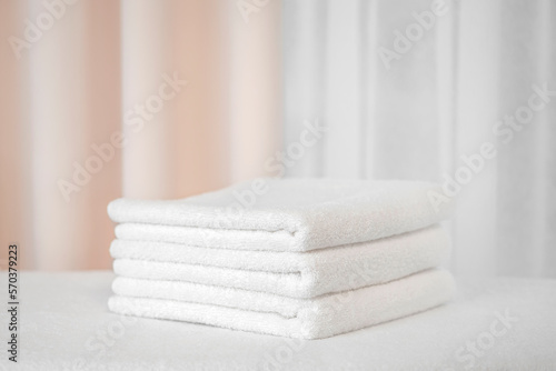 Three white terry bath towels on a light background