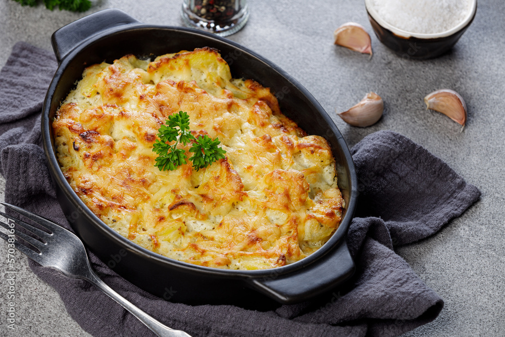 Potato casserole with cheese and parsley on stone background. French cuisine, top view Potato casserole with cheese and parsley on stone background. French cuisine, top view