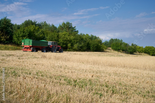 Tractor with trailer in grain field