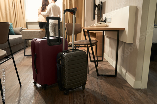 Young travelers stand at the window in a hotel room