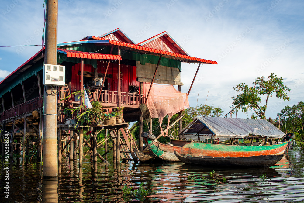 Floating Village on the water of a river in Thailand, colorful reflection on the water, pier and houses