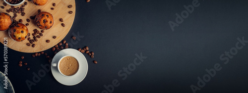 Desayuno con taza de café, muffins de chocolate, en madera, con granos de café, en fondo banner largo oscuro azul