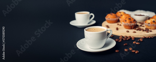 Dos tazas de café, desayuno con muffins de chocolate, en una bandeja de madera, granos de café en fondo banner largo azul oscuro