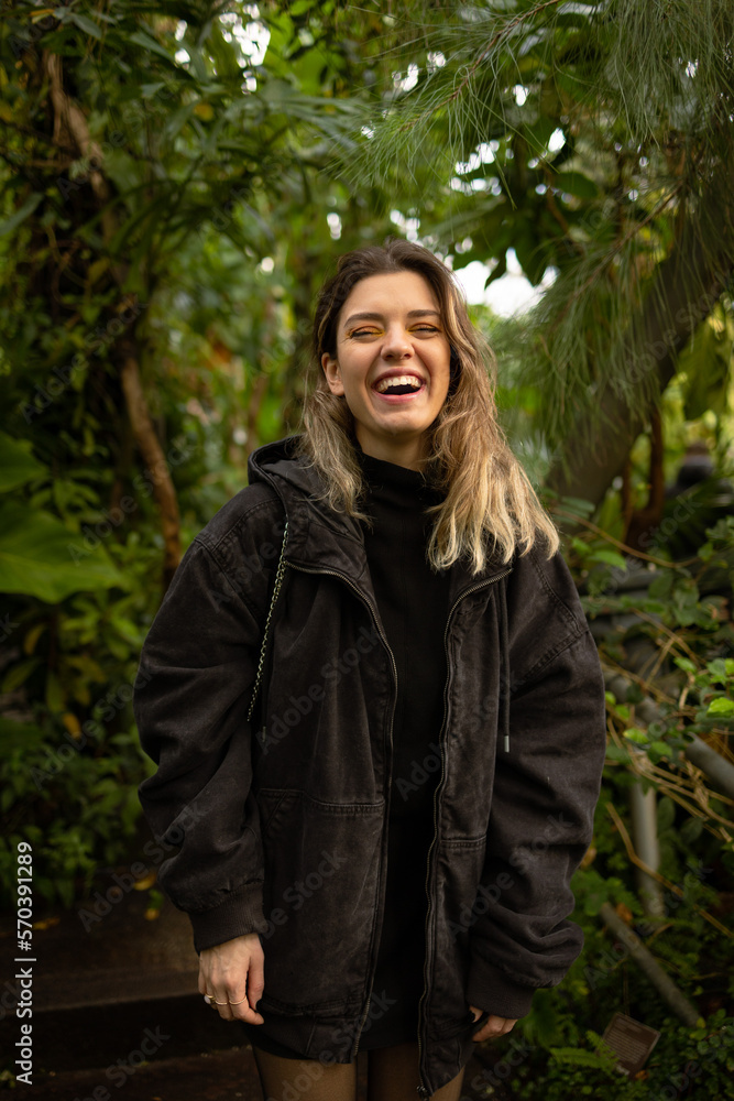 Young beautiful woman looking at camera and laughing. Nature love and fresh air concept. Young beautiful woman looking at camera and laughing. Nature love and fresh air concept.