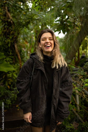 Young beautiful woman looking at camera and laughing. Nature love and fresh air concept.