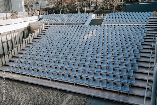 Field of empty plastic blue chairs seats on stadium.