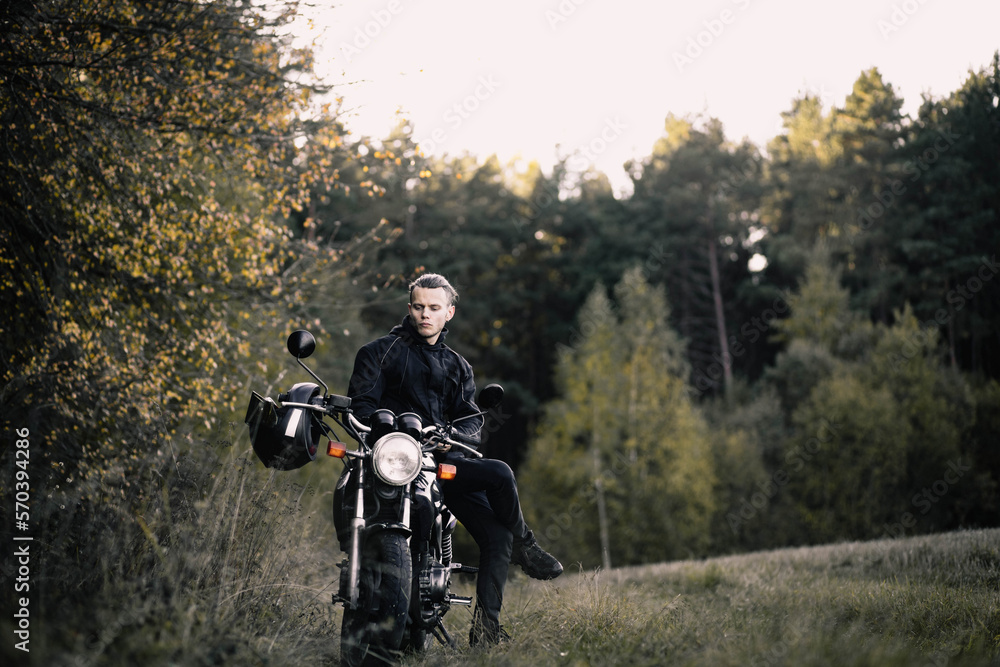 man with a motorcycle in the outfit in the spring the beginning of the motorcycle season. man with a motorcycle in the outfit in the spring the beginning of the motorcycle season.