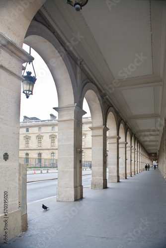 Paris ancient stone building colonnade with a lamp, dove and distant human figures