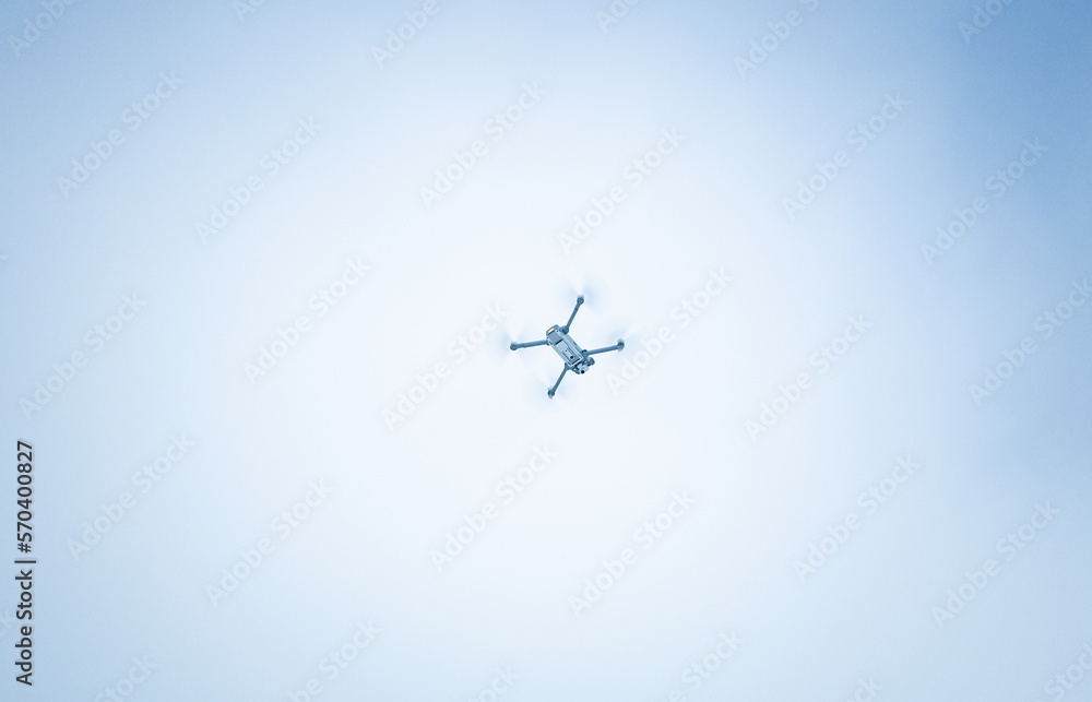 Flying gray drone in the sky. Flying gray drone in the sky.