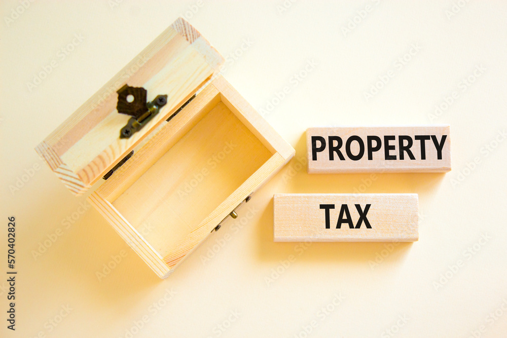 Property tax symbol. Concept words Property tax on wooden blocks. Beautiful white table white background. Wooden empthy chest. Business and property tax concept. Copy space. Property tax symbol. Concept words Property tax on wooden blocks. Beautiful white table white background. Wooden empthy chest. Business and property tax concept. Copy space.