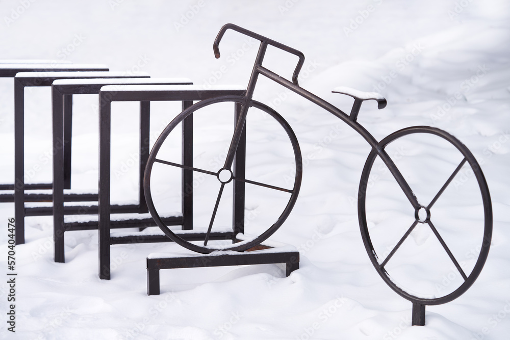 After the snowstorm. A snow-covered empty bicycle parking lot with a decorative element - a metal bicycle. After the snowstorm. A snow-covered empty bicycle parking lot with a decorative element - a metal bicycle.