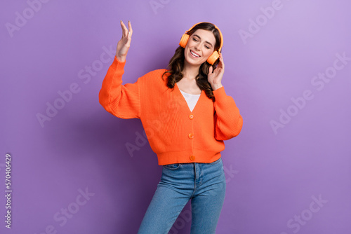 Fototapeta Photo of youngster curly brunette woman listen her orange headphones wear trendy