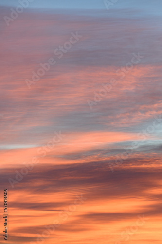 Fototapeta Naklejka Na Ścianę i Meble -  Sky with soft and fluffy pastel orange pink and blue colored clouds. Sunset background. Nature. sunrise. Instagram toned style. Vertical