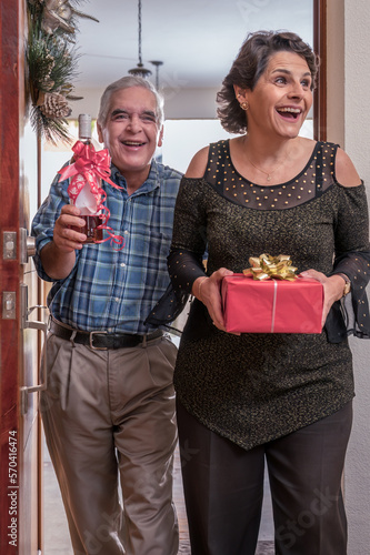 Esposos llegan felices a la casa de sus amigos con regalos para compartir. photo