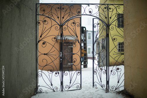 Steel gate in old town in winter. Forged gates. Entrance to courtyard.