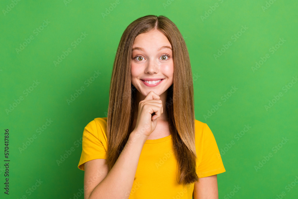 Photo of minded clever positive girl hand touch chin beaming smile isolated on green color background Photo of minded clever positive girl hand touch chin beaming smile isolated on green color background
