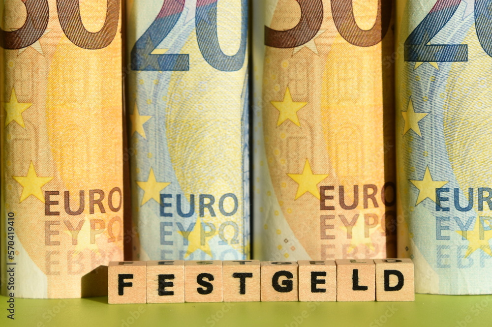 Mehrere gerollte Geldscheine und das Wort Festgeld Mehrere gerollte Geldscheine und das Wort Festgeld