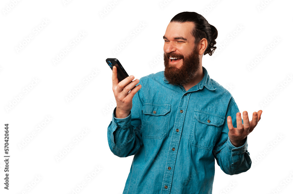 Portrait of a cheerful handsome man is having a conversation over the phone on speaker. Portrait of a cheerful handsome man is having a conversation over the phone on speaker.
