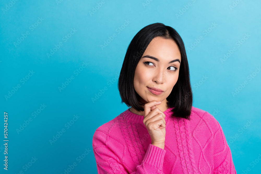 Portrait of funny suspicious minded woman wear pink knitted jumper touch chin looking empty space hmm deep think isolated on blue color background Portrait of funny suspicious minded woman wear pink knitted jumper touch chin looking empty space hmm deep think isolated on blue color background