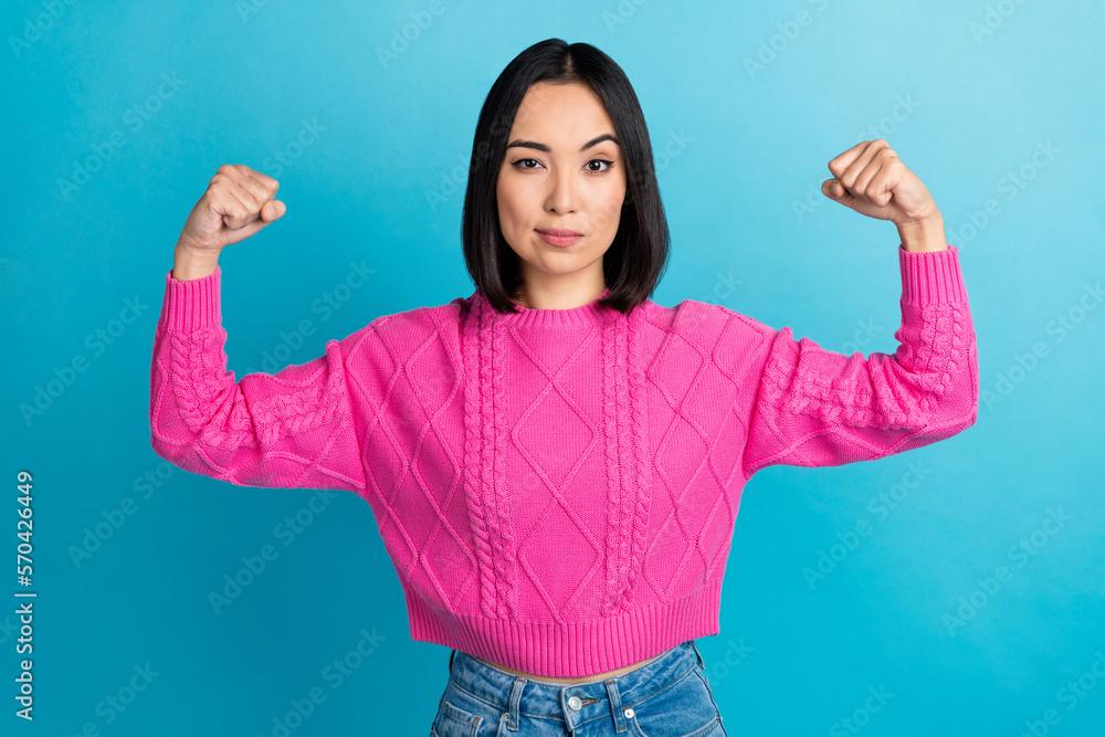 Photo of successful strong malaysian girl arms flex demonstrate biceps isolated on blue color background Photo of successful strong malaysian girl arms flex demonstrate biceps isolated on blue color background
