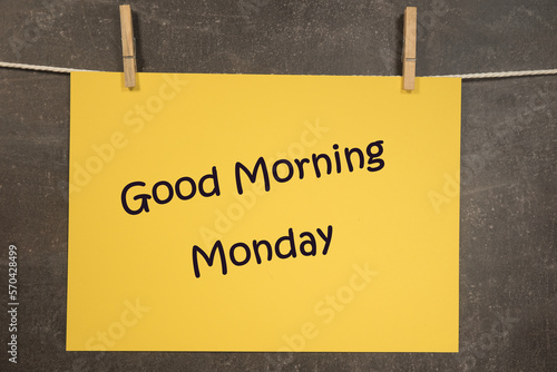 Napis dzień dobry poniedziałek. Napis na żółtej kartce zawieszonej na ciemnym tle