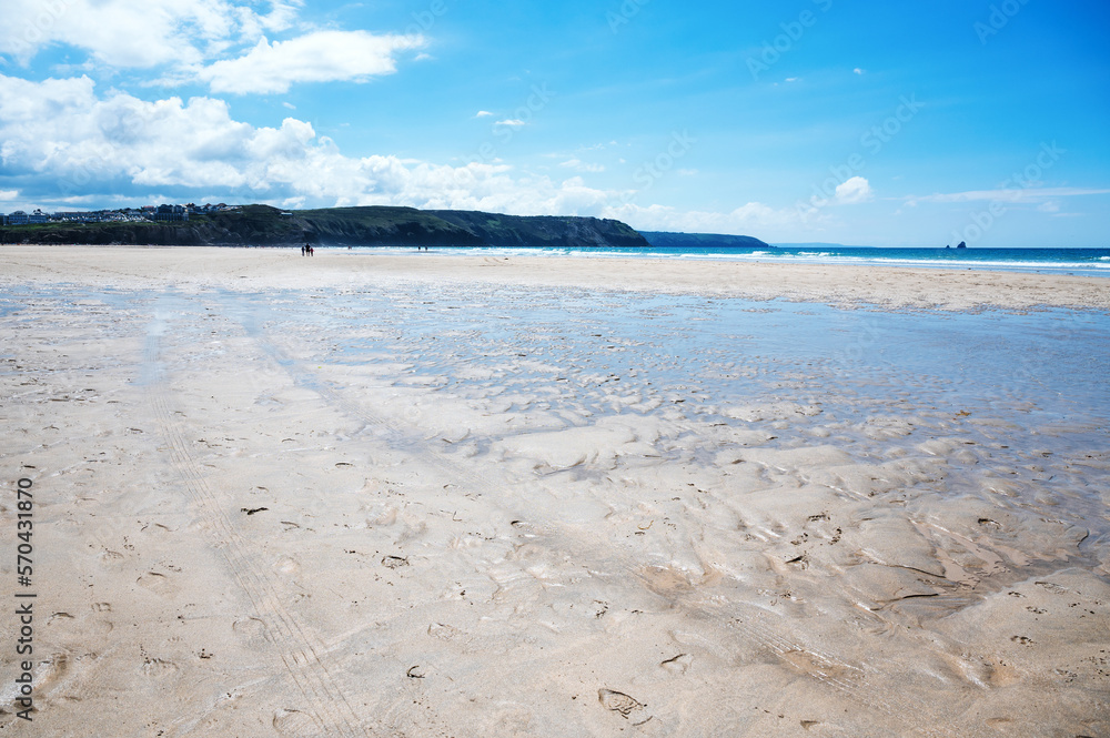 Beautiful Newquay beach with blue sea, stone cliffs and white sand in Cornwall, south west England, selective focus