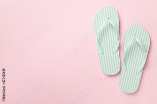 Striped flip flops on color background, top view