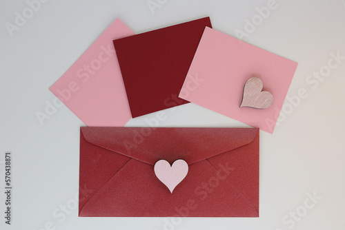 Burgundy envelope with pink and burgundy paper slips for writing text with hearts decoration