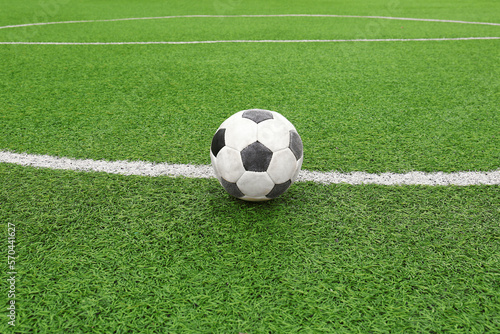 Dirty soccer ball on green football field © New Africa