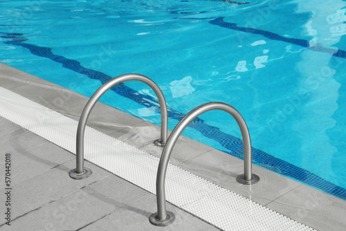 Ladder with handrails in outdoor swimming pool