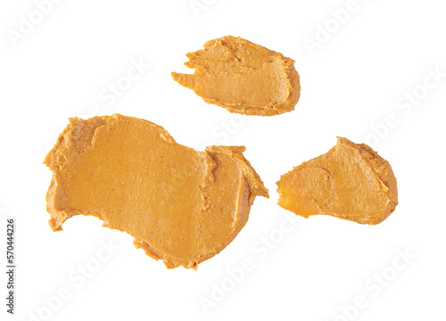 smears or splashes of peanut butter isolated on white background, top view.