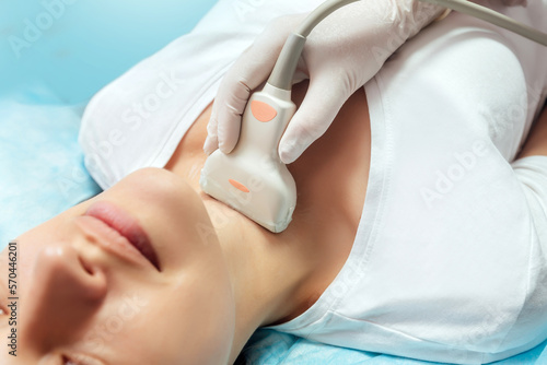 Young woman patient during the ultrasound examination of a thyroid lying on the couch
