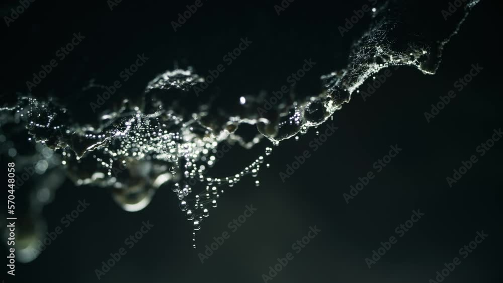 Dolly shot of drops dripping from rocks in cave Dolly shot of drops dripping from rocks in cave
