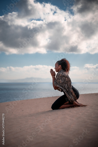 silhouette of girl praying with sea in background