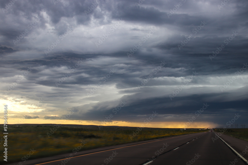 Rural highway passes dramatic skies, over the prairie - Eastern Colorado