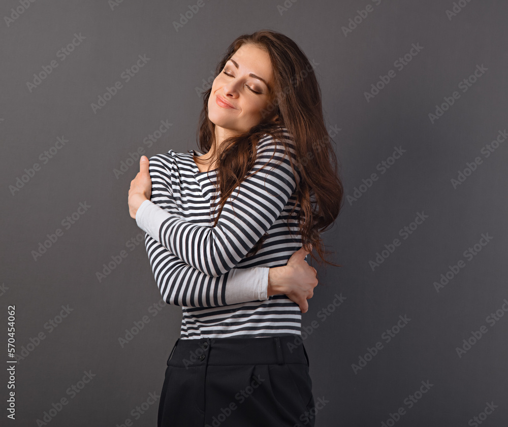 Beautiful happy smiling woman hugging herself with love Beautiful happy smiling woman hugging herself with love