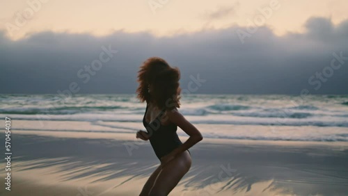 Girl performer dancing seashore at summer evening. Woman moving body smoothly.