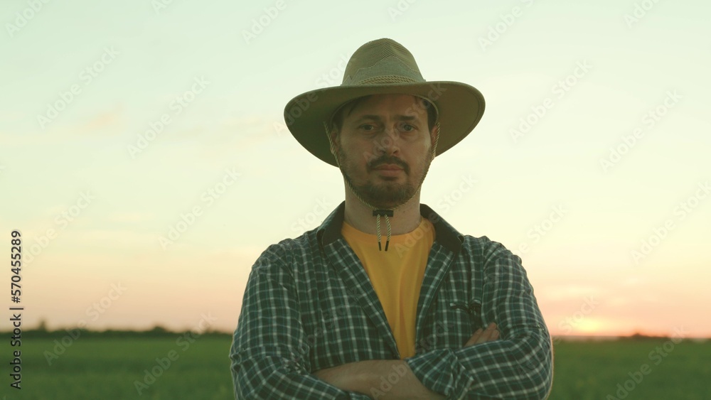Portrait of the thoughtful senior farmer looks at camera. Senior Farmer smiling. Slow motion. Close up of the Caucasian good looking young man with a beard smiling to the camera