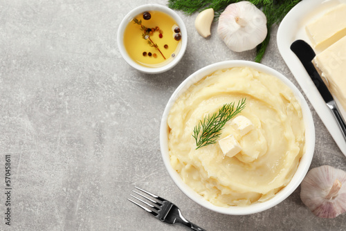 Delicious mashed potato with dill and butter served on light grey table, flat lay. Space for text