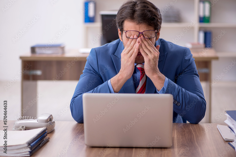 Young male employee working in the office Young male employee working in the office
