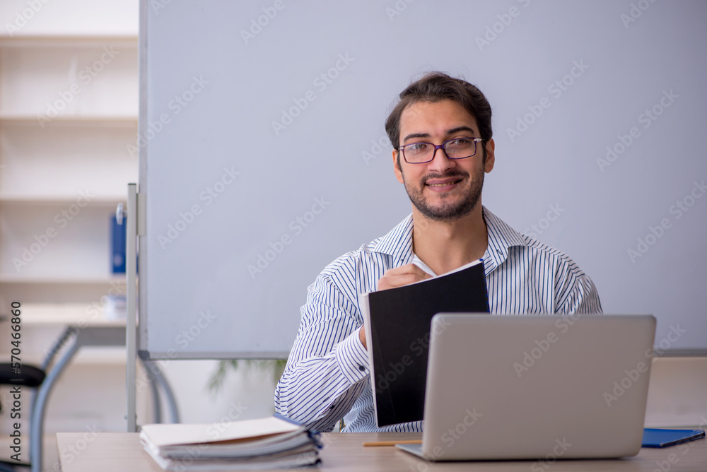 Young male teacher sitting in the classroom Young male teacher sitting in the classroom