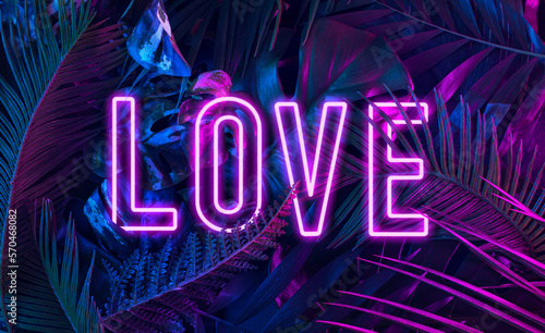 Fototapeta Naklejka Na Ścianę i Meble -  Trendy composition made of fluorescent color layout made of tropical jungle leaves. Flat lay neon colors in the shape of the word 