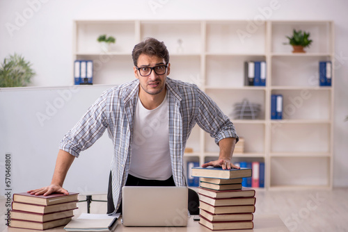 Young male student preparing for exams in the classroom