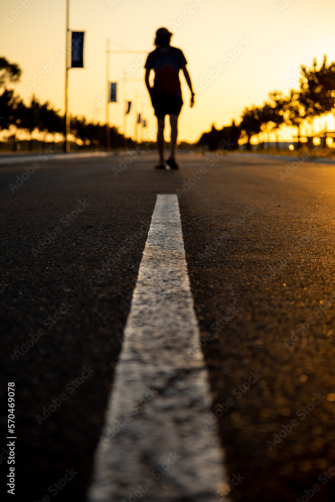 Person walking on the street at sunset