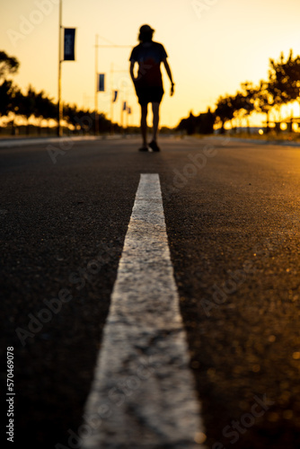 Person walking on the street at sunset