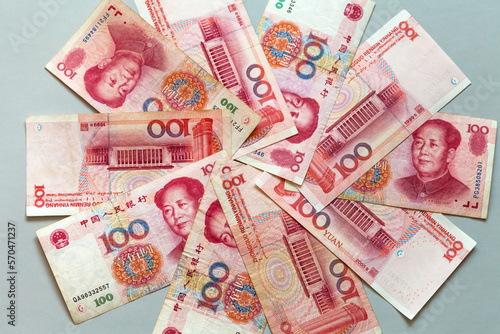 Paper money in denominations of 100 yuan are laid out in a circle on a light table. Chinese economy and finance. Currency background. The concept of finance, banking, investment, business and lending photo
