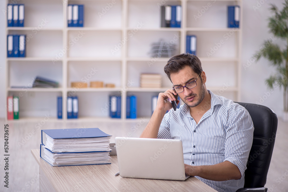 Young male employee working in the office Young male employee working in the office