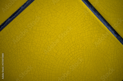 Closeup of a Crazed Yellow Tile with Charcoal Gray Grout.