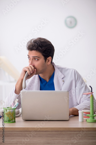 Young male dentist working in the clinic